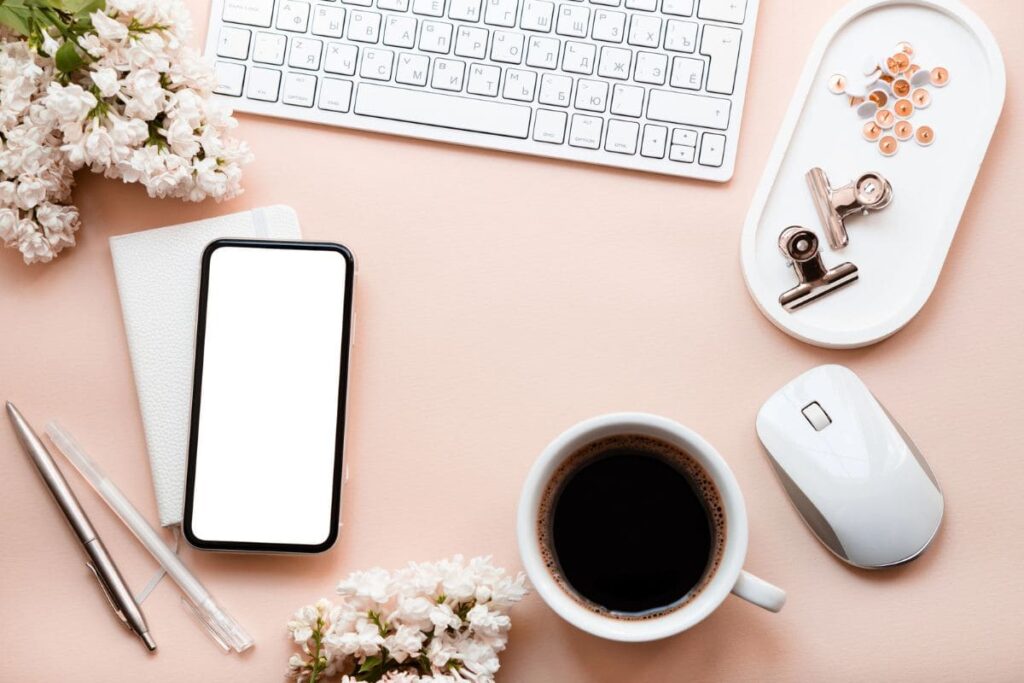 Overhead image of wedding flowers and accessories on a remote worker's desk.