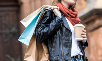 A female holding shopping bags and a coffee for blog post make money shopping