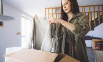 A young woman opening a package after shopping on Poshmark