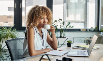 A young woman with a nose ring doing internet research on her laptop at home