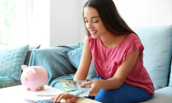 A young woman with long hair counting money from her job that pays daily