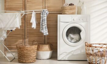 A laundry room in a remote worker's home, with a washing machine, drying rack, and laundry baskets for blog post get paid to do laundry
