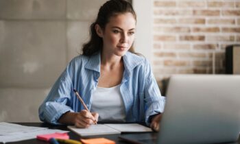 An entrepreneur working from her home office on a laptop for blog post how to advertise your business for free