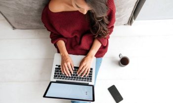 Woman with anxiety sitting on the floor and working from home on a laptop, for blog post low-stress jobs